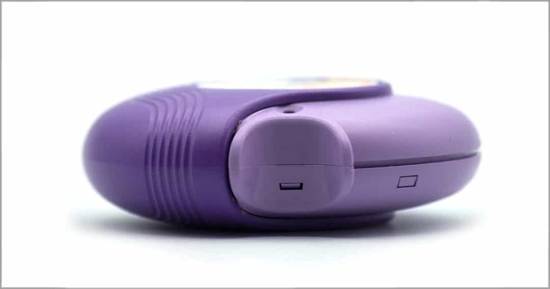 A close-up photo of a purple asthma inhaler diskus device, shown from the side against a white background.