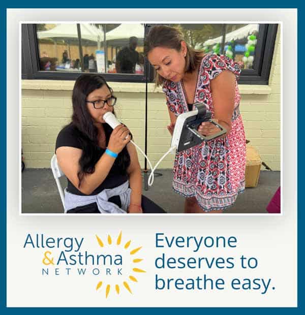 A woman assists another woman using a breathing test device at an outdoor event. Text reads: "Allergy & Asthma Network. Everyone deserves to breathe easy.